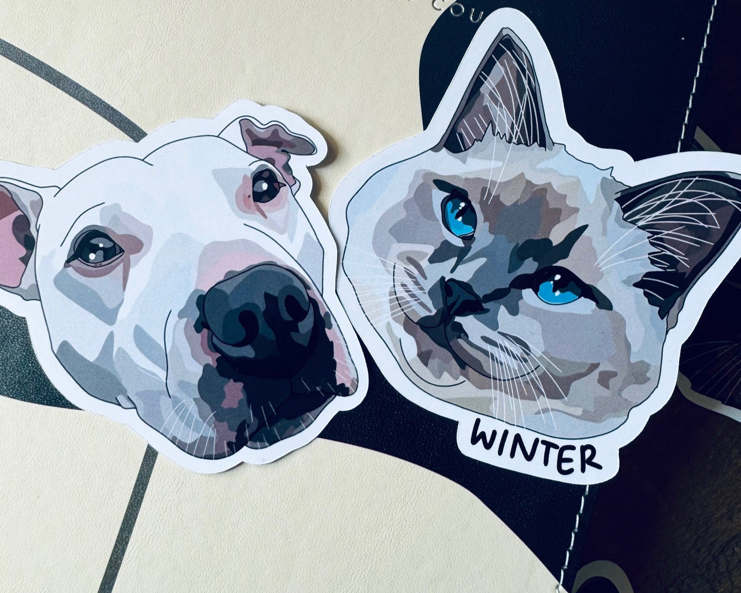 Two dog stickers on a surface with text and design elements.