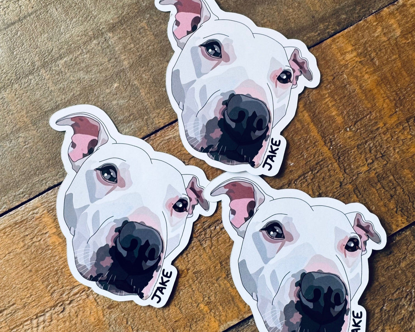 Three dog stickers on a wooden surface