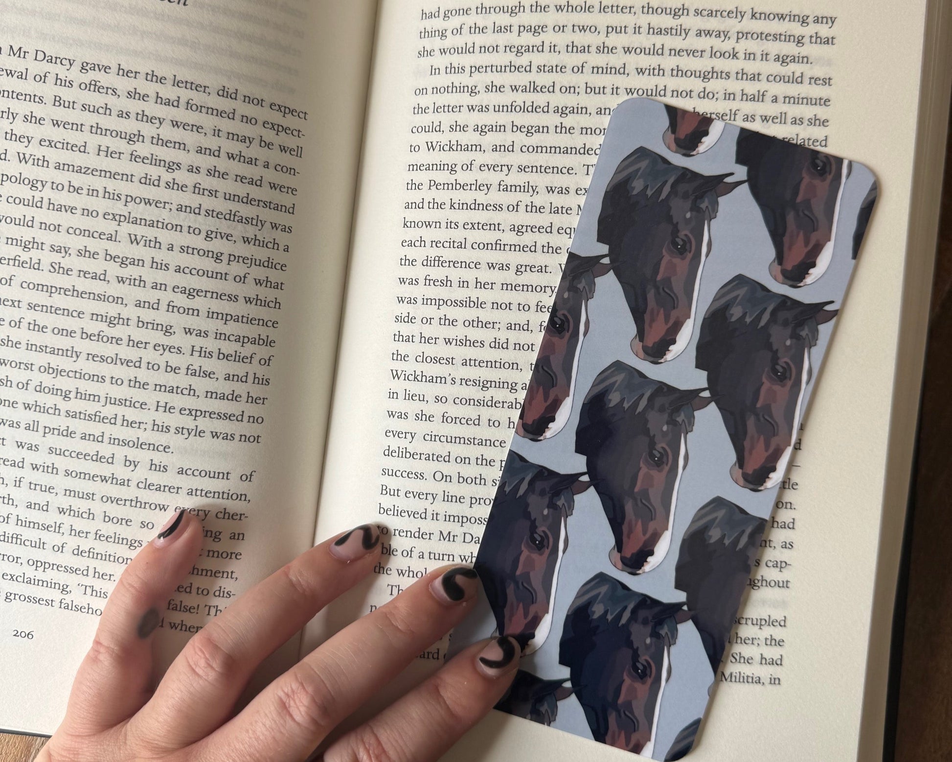 Open book with a hand holding a horse portrait bookmark