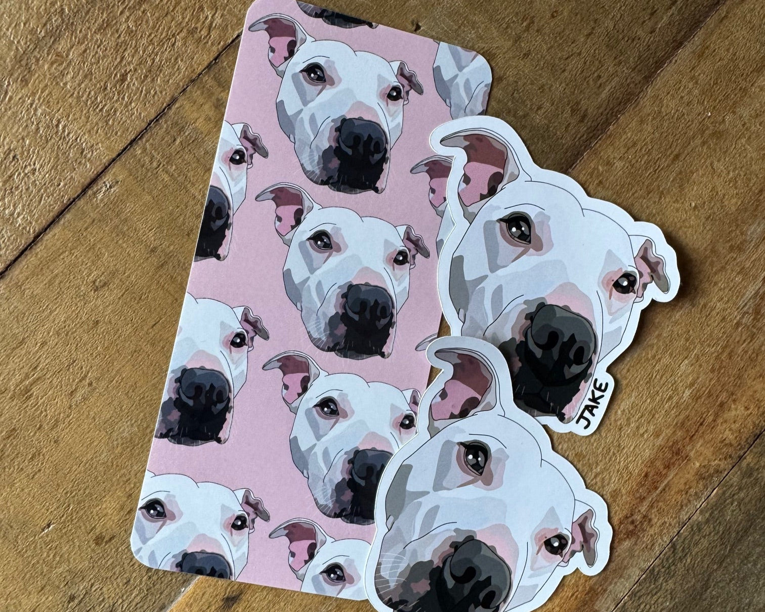 Sticker with dog pattern on a pink background, placed on a wooden surface.