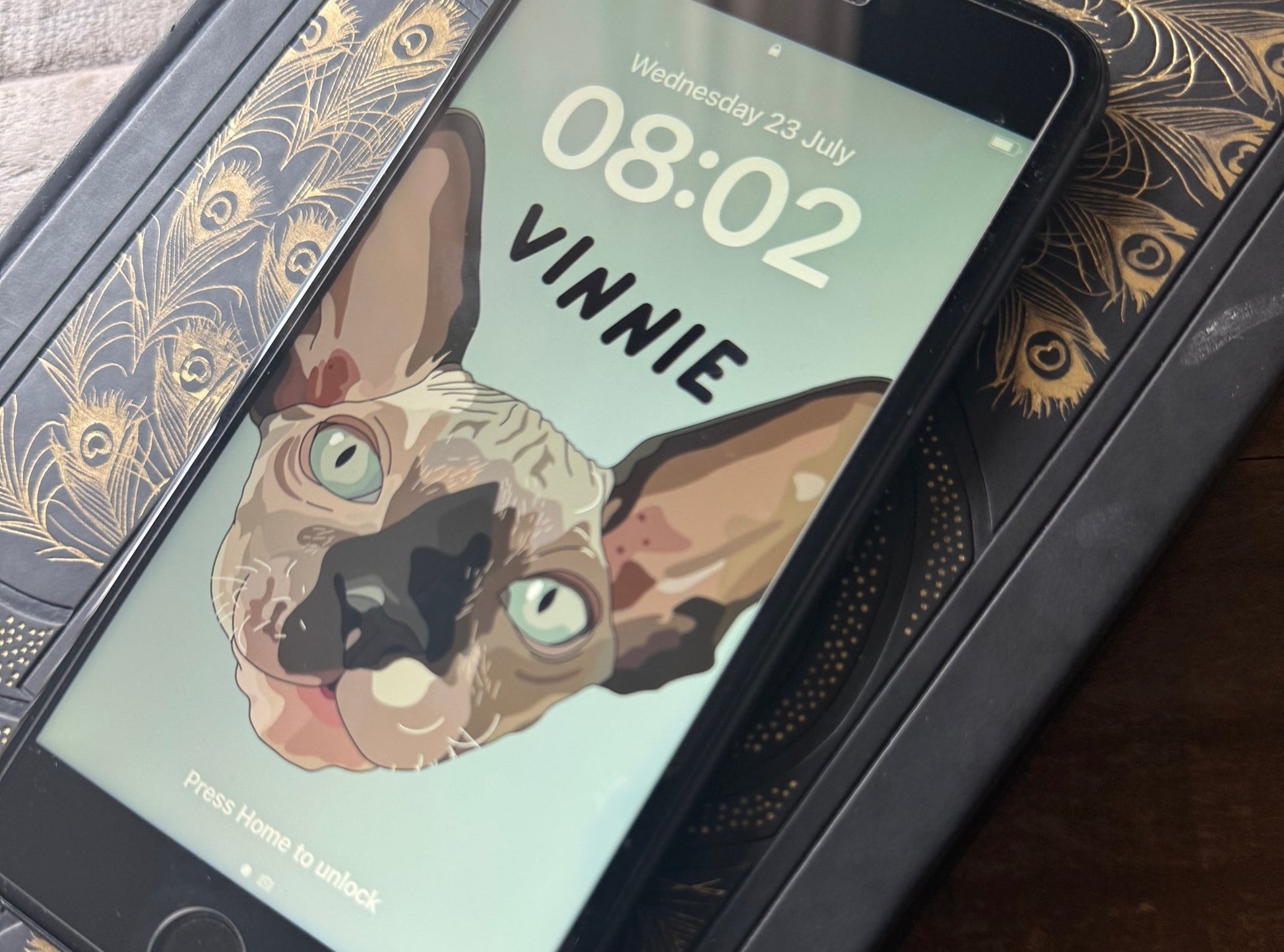 Phone displaying an app with a cat illustration on a decorative stand.